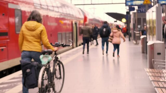 passengers late, running to German railway train, platform Frankfurt am Main station, out of focus video, people with luggage and backpack go to board, boarding travelers in cars, Frankfurt, Germany