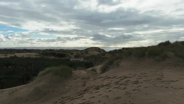 Sand dune beach view of the irish sea and wind turbines (Formby, Liverpool) wide shot