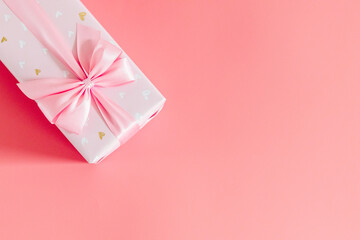 One gift box with a bow on a pink background.