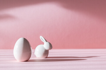 Porcelain Easter eggs and bunny on a pink background.