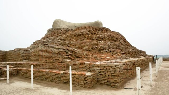 Stupa, brick construction, fenced historical site, cloudy sky. Mohenjo daro, Sindh, Pakistan.
