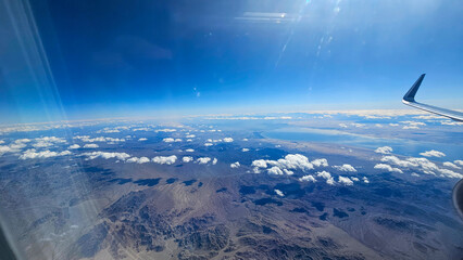 an aerial shot for majestic mountain ranges and water and powerful clouds and blue sky in California USA