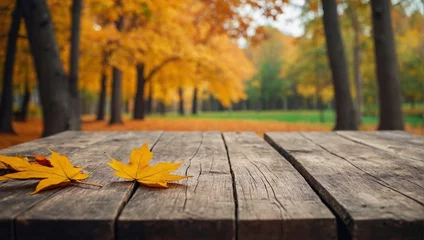  Empty blank wooden table fall background with autumn trees orange yellow color leaves backdrop forest or park nature scene abstract blurred bokeh tabletop for product display desk mockup. © Leon Rahman