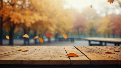 Schilderijen op glas Empty blank wooden table fall background with autumn trees orange yellow color leaves backdrop forest or park nature scene abstract blurred bokeh tabletop for product display desk mockup. © Leon Rahman