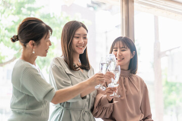 女子会でレストラン・カフェ・飲食店でシャンパンを持って乾杯する女性達（アジア人）
 - obrazy, fototapety, plakaty