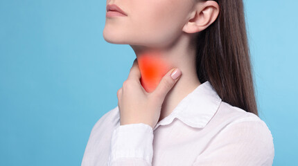 Endocrine system. Woman doing thyroid self examination on light blue background, closeup. Banner...