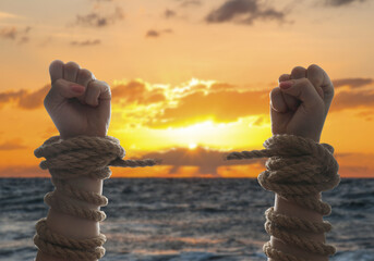 Freedom. Woman with ripped ropes near sea at sunset, closeup