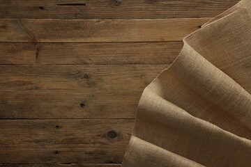 Burlap fabric on wooden table, top view. Space for text