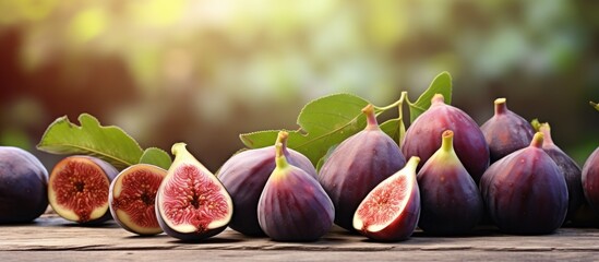 A collection of ripe fig fruits is neatly arranged on a wooden table, creating a visually appealing display. The figs sit elegantly, showcasing their natural beauty and rich colors. - obrazy, fototapety, plakaty