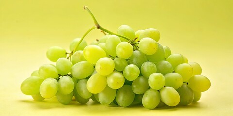 Fresh green grapes arranged on a vibrant yellow background, creating a colorful and visually appealing image. 