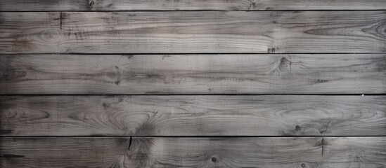 Obraz na płótnie Canvas The image shows a wooden wall with a grey hue. The rugged texture of the wood is highlighted in the black and white contrast, providing a simplistic yet detailed view of the surface.