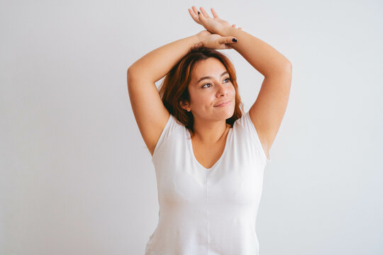 plus size curvy young latin woman with her arms up happy. copy space