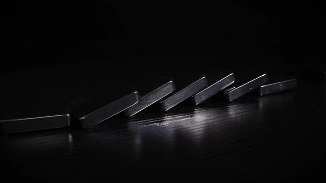 Black domino tiles falling collapsing on table 1