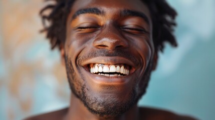 Handsome unshaven young dark-skinned male laughing out loud at funn