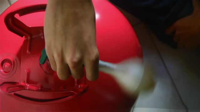 A Man Inflating A White Balloon While Preparing A Birthday Party. Close Up. 4K Resolution.