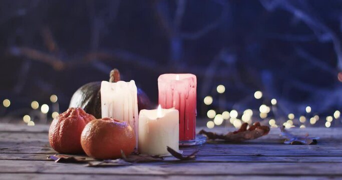 Candles and pumpkins set a cozy, festive mood on a wooden surface