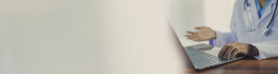 Doctor using a computer in office copy spec background