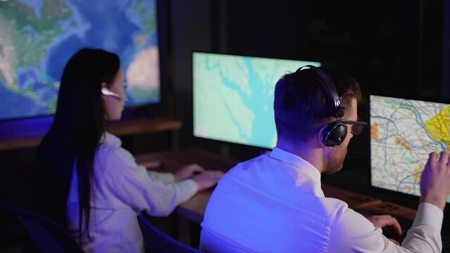 Two delivery operators in headphones discussing the route with the truck drivers or customers in call center