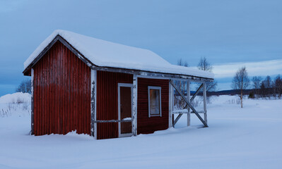 Frozen hut in front of an ice plain in deep Winter in northern Finland, above the arctic circle, around Muonio.