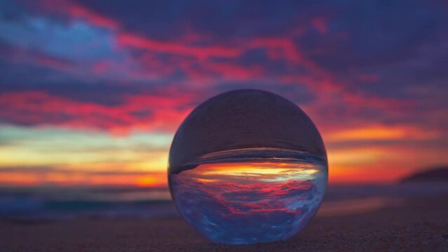 Amazing view of colorful cloud in sky of sunset inside crystal ball. .The natural view of the sea and sky in beautiful sunset on Phuket beach. .AN image for a unique and creative travel.