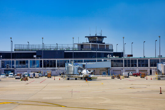 View of the Apron area at the Chicago O'Hare International Airport. An airplane next to the a passenger bridge being serviced before taking off. Chicago, IL USA on June 22, 2022.