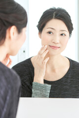 鏡をみる中年女性