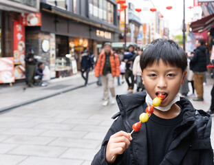 横浜中華街でいちご飴を食べる男の子
