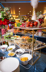 Delicious buffet spread with salads, vegetables, and snacks for events. Blue background.