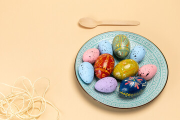 Easter eggs on a dish with the beige background.