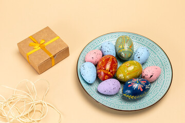 Plate with colored Easter eggs and a gift box.