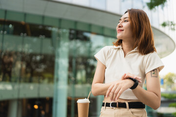 Business asian woman use smart watch standing on modern office building - 749189951