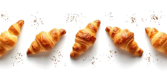 Afwasbaar fotobehang A group of freshly baked croissants arranged neatly on a white surface, creating a visually appealing French breakfast concept. The golden-brown pastries are a delicious and flaky treat that promote © 2rogan