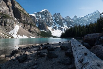 A small stream meanders gracefully at the foot of the snow-capped mountain, its crystal-clear...