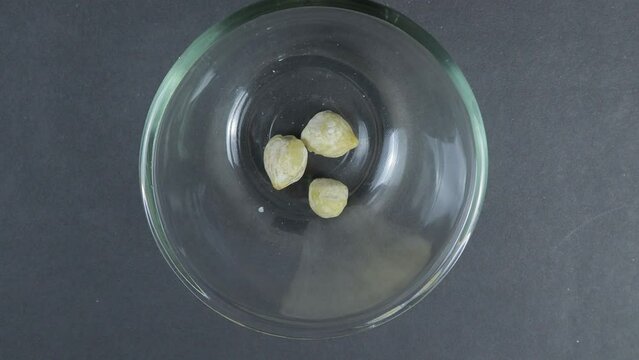 Close up top view of Candlenuts (Aleurites moluccana) poured into a glass bowl