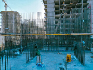 A construction site with a lot of scaffolding and a building in the background. Scene is one of hard work and progress