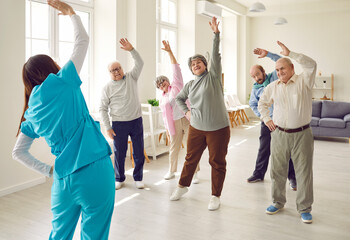 Nurse or physiotherapist doing healthy stretching exercises for wellness and health with a group of...