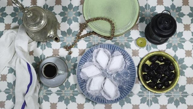 eid al fitr or aldha, ramadan concept iftar and breakfast. women drinking coffee and eating algeria cookies made from almond paste and covered with sugar powder, dates, lantern