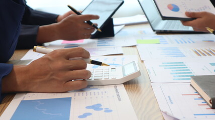 Close up of hands of business people working together in a conference room, brainstorming, discussing and analyzing and planning business strategies.