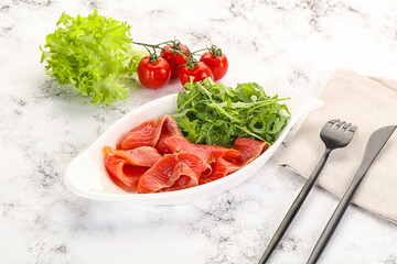 Sliced salmon with fresh arugula