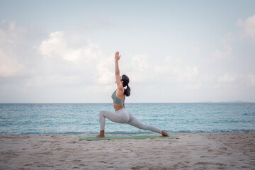Fototapeta na wymiar Young sport woman wearing sport suit practice yoga on the beach .Yoga is meditation and healthy sport relaxing on summer holiday with blue sea and sky background.