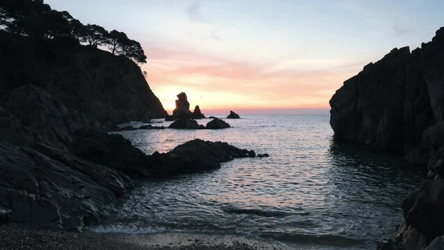 Sunrise at the rocky coastline of the sea
