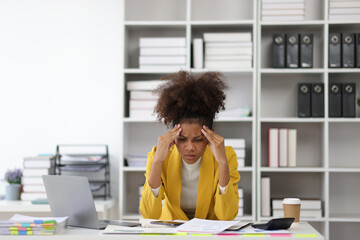 Stress and pressure of overwork. African woman in office stressed with paperwork and worried about...