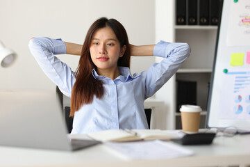 Asian woman working in office stretching relaxation during break to relieve fatigue.