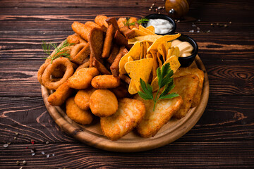 Bar menu fried chicken fillet, crispy onion rings, cheese sticks, garlic croutons, nachos, sauces and greens.