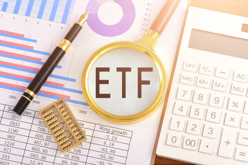 The magnifying glass on the chart is printed with the letter ETF