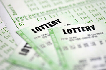 Green lottery tickets and blank bills with numbers for playing lottery close up