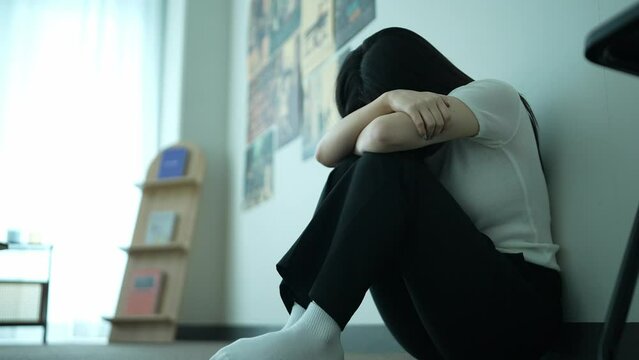 Sad and Tormented Woman Leaning Against the Wal