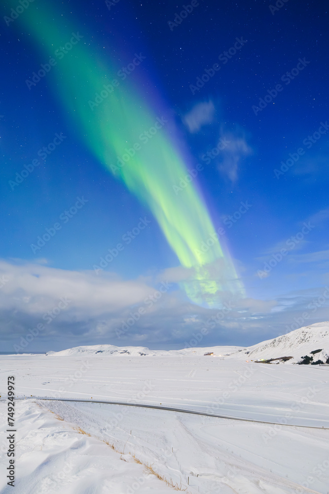 Wall mural aurora borealis in iceland. northern lights over snow field. a winter night landscape with bright li