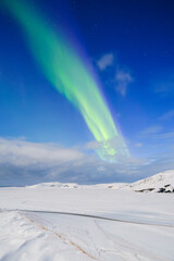 Aurora Borealis in Iceland. Northern Lights over snow field. A winter night landscape with bright lights in the sky. Landscape in the north in winter time. A popular place to travel. - 749249973