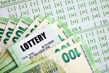 Green lottery tickets and euro money bills on blank with numbers for playing lottery close up